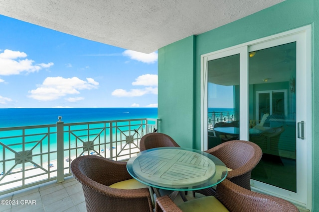 balcony featuring a water view and a beach view