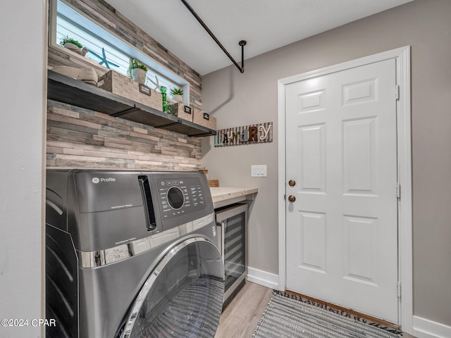 laundry area featuring wine cooler, light hardwood / wood-style floors, and separate washer and dryer