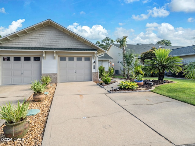 view of front of home with central AC unit and a garage