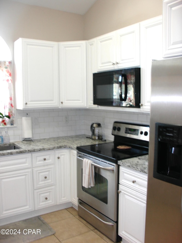 kitchen featuring light tile patterned floors, white cabinetry, stainless steel appliances, backsplash, and light stone counters