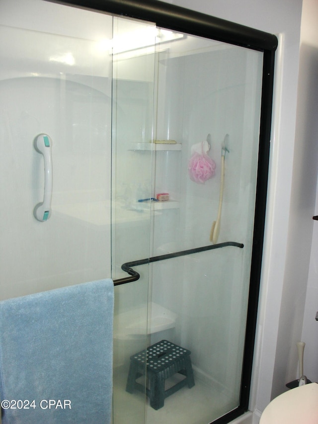 bathroom with an enclosed shower and toilet