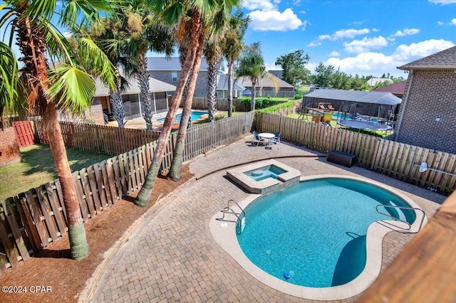 view of pool featuring an in ground hot tub and a patio