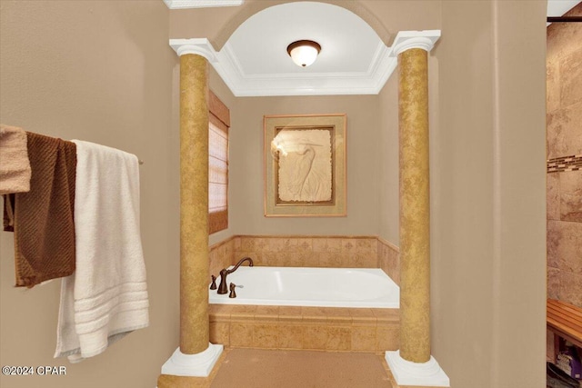 bathroom featuring decorative columns, crown molding, and tiled tub