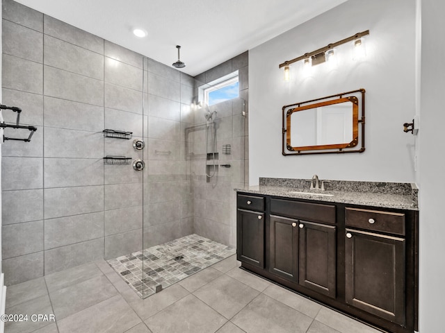 bathroom featuring vanity, tiled shower, and tile patterned floors