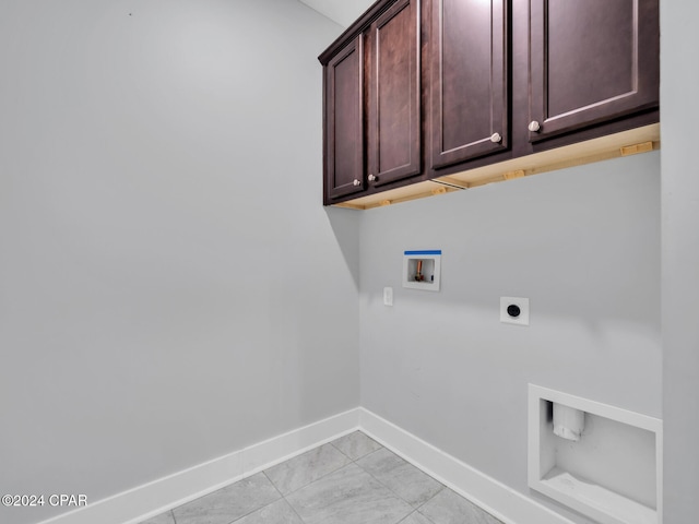 laundry room featuring hookup for a washing machine, electric dryer hookup, cabinets, and light tile patterned flooring