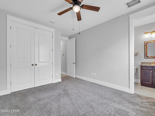 unfurnished bedroom with light carpet, connected bathroom, and ceiling fan