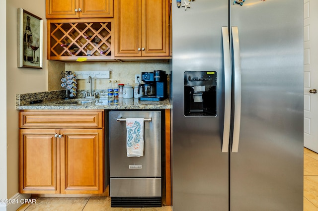 kitchen featuring light tile patterned floors, sink, backsplash, stainless steel refrigerator with ice dispenser, and dark stone counters