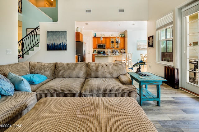 living room featuring light wood-type flooring and a high ceiling