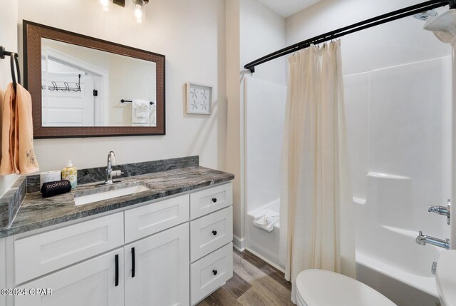 full bathroom featuring toilet, vanity, wood-type flooring, and shower / bathtub combination with curtain