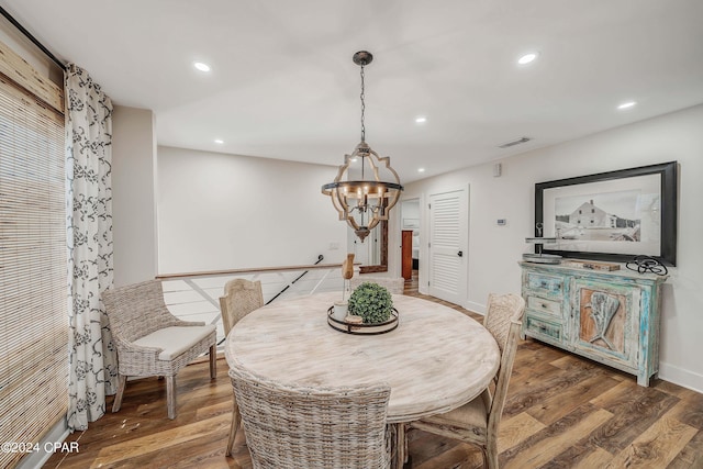 dining room featuring dark wood-type flooring and an inviting chandelier