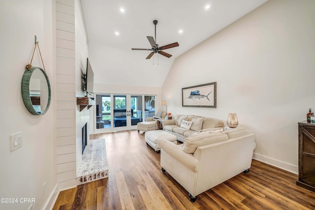 living room with ceiling fan, hardwood / wood-style floors, high vaulted ceiling, a fireplace, and french doors