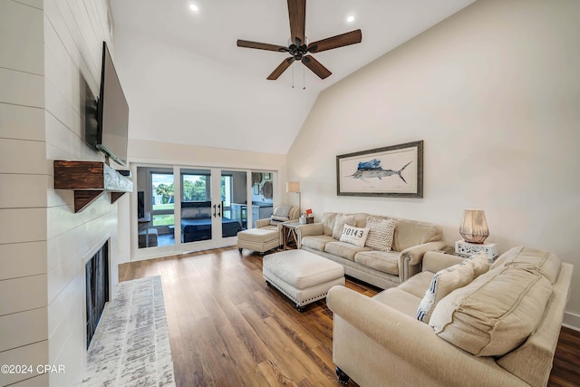 living room featuring hardwood / wood-style floors, a large fireplace, ceiling fan, and high vaulted ceiling