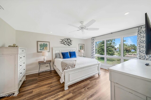 bedroom with ceiling fan, crown molding, and dark wood-type flooring