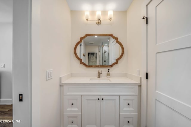 bathroom featuring wood-type flooring, vanity, and a shower with shower door