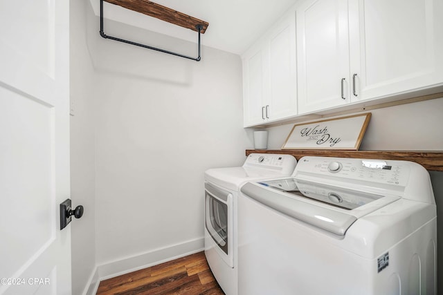 clothes washing area with cabinets, dark hardwood / wood-style floors, and washing machine and dryer