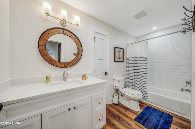 full bathroom with hardwood / wood-style flooring, shower / bath combo, vanity, and toilet