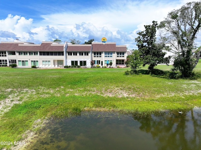 back of house featuring a water view and a yard