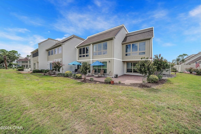 back of property featuring a yard and a patio