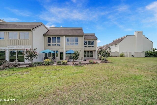 rear view of house with a patio and a yard