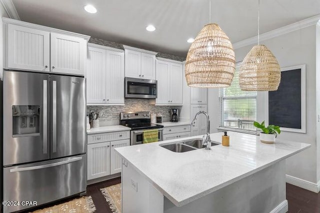 kitchen with tasteful backsplash, ornamental molding, white cabinetry, appliances with stainless steel finishes, and sink