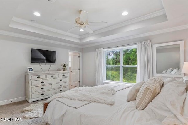 bedroom with ceiling fan, carpet, ornamental molding, and a tray ceiling