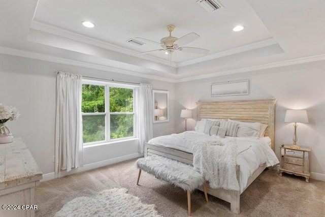 carpeted bedroom featuring a tray ceiling, baseboards, visible vents, and ornamental molding