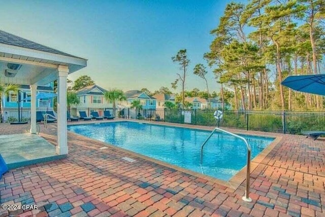 pool featuring a residential view, a patio, and fence