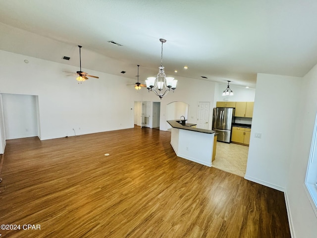 kitchen with light wood-style flooring, a sink, open floor plan, freestanding refrigerator, and dark countertops