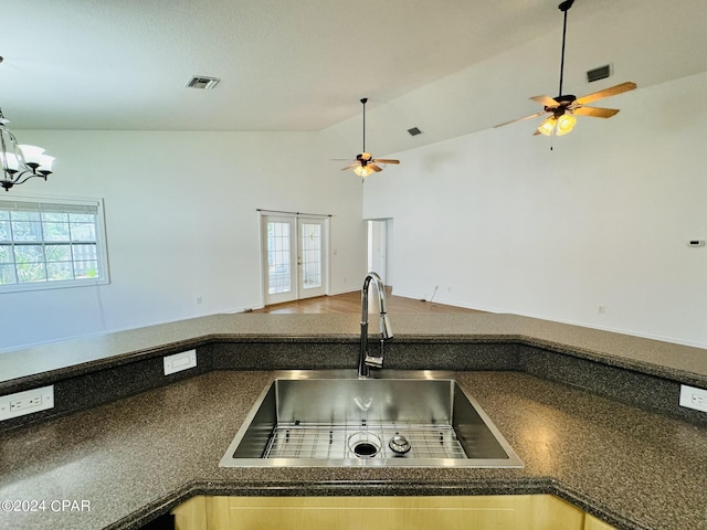 kitchen featuring dark countertops, open floor plan, visible vents, and a sink