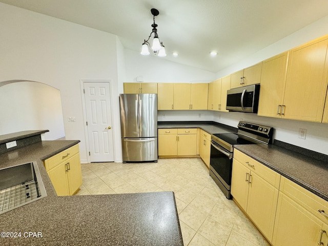 kitchen featuring dark countertops, light brown cabinets, stainless steel appliances, and lofted ceiling