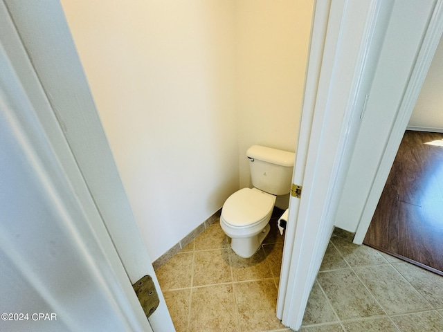 bathroom featuring baseboards, toilet, and tile patterned floors