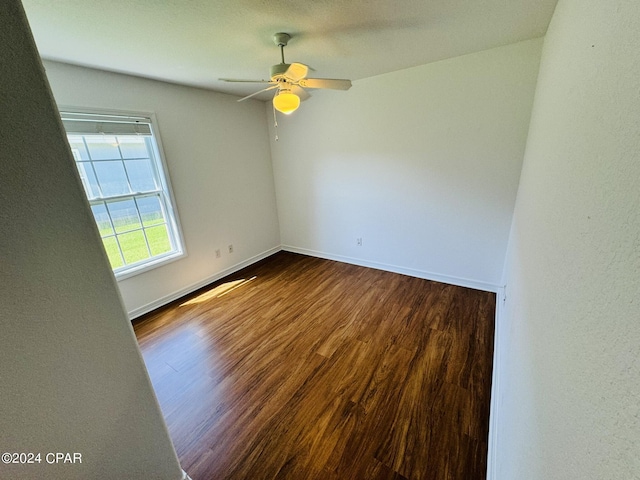 unfurnished room with dark wood finished floors, baseboards, and ceiling fan