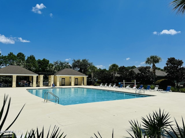 community pool with a gazebo and a patio area