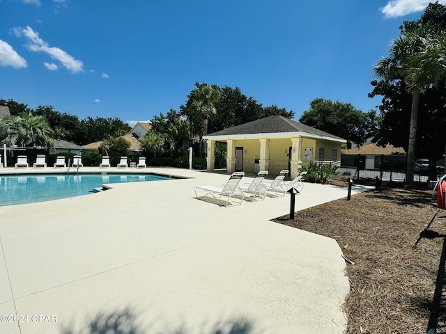 pool with a patio area and fence