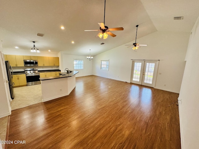 kitchen featuring wood finished floors, visible vents, open floor plan, appliances with stainless steel finishes, and dark countertops