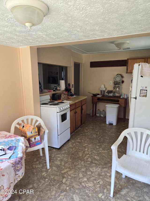 kitchen with a textured ceiling and white appliances