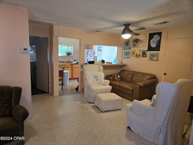 living room with a textured ceiling and ceiling fan