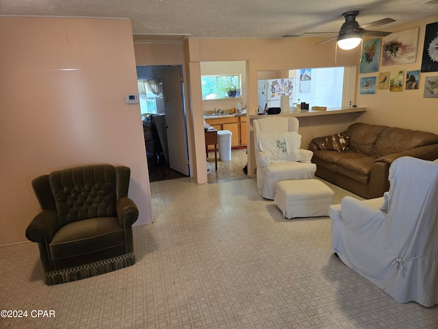 living room with a textured ceiling and ceiling fan