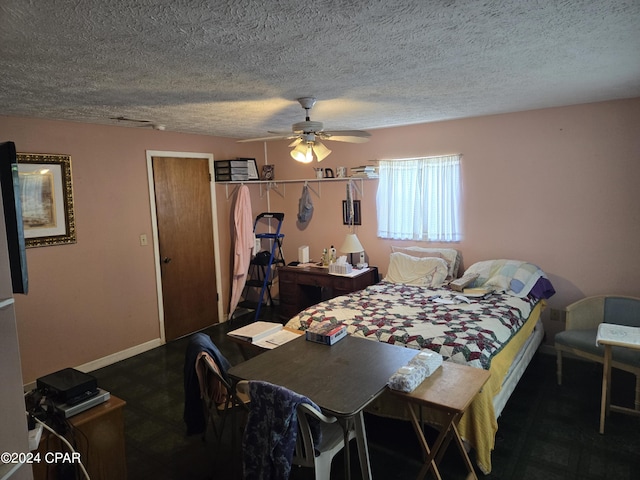 bedroom with ceiling fan and a textured ceiling