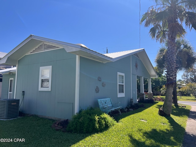 view of side of property featuring a yard and central AC unit