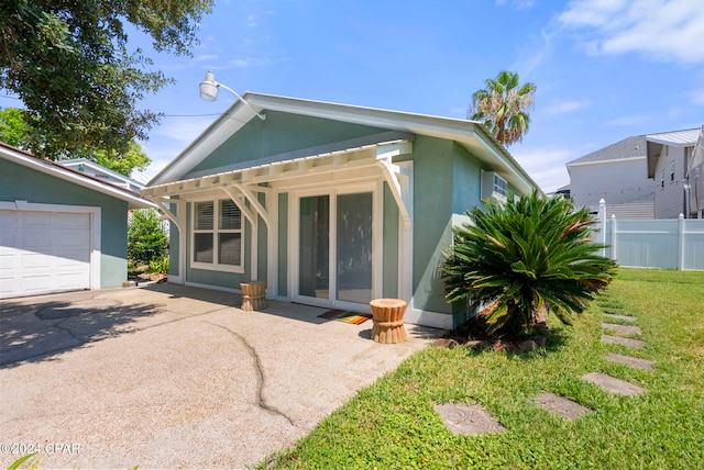 view of front of home featuring a front lawn, an outdoor structure, and a garage