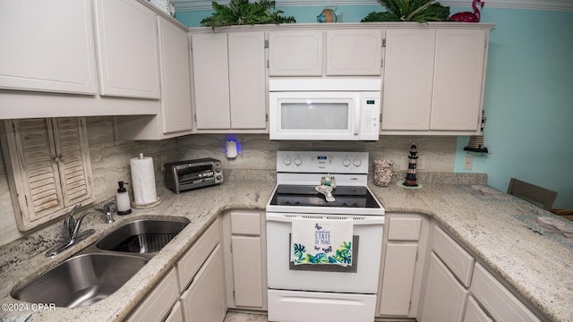 kitchen with white cabinets, white appliances, light stone counters, sink, and tasteful backsplash