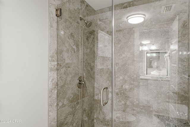 bathroom with a shower with door