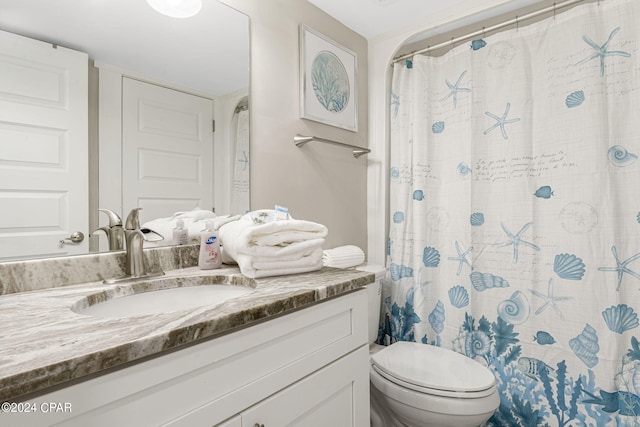 bathroom featuring vanity, toilet, and walk in shower