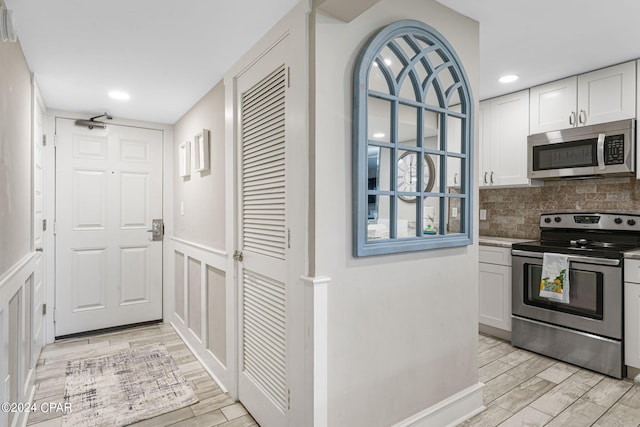 kitchen featuring backsplash, stainless steel appliances, and white cabinets