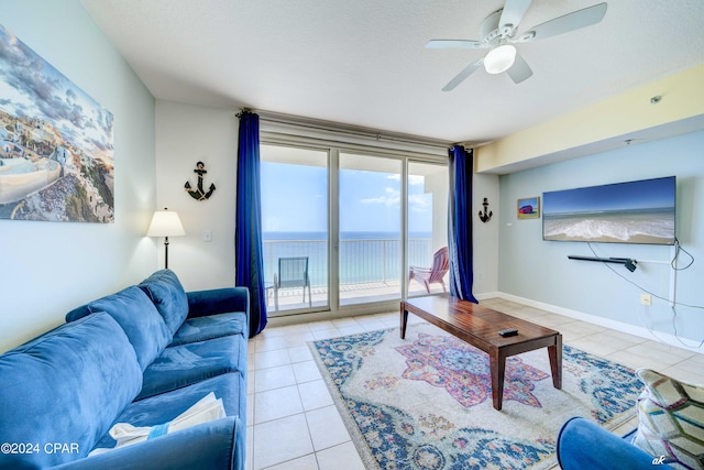 tiled living room featuring ceiling fan and baseboards