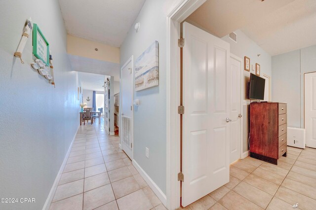 hall featuring light tile patterned floors