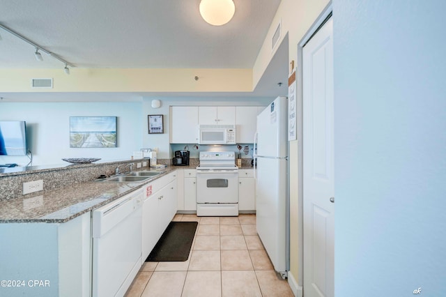 kitchen with white cabinets, light tile patterned flooring, sink, white appliances, and stone countertops