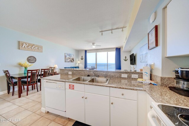 kitchen with light tile patterned floors, white cabinets, a sink, a ceiling fan, and white appliances