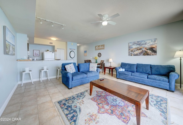 living room featuring ceiling fan, baseboards, rail lighting, and light tile patterned floors